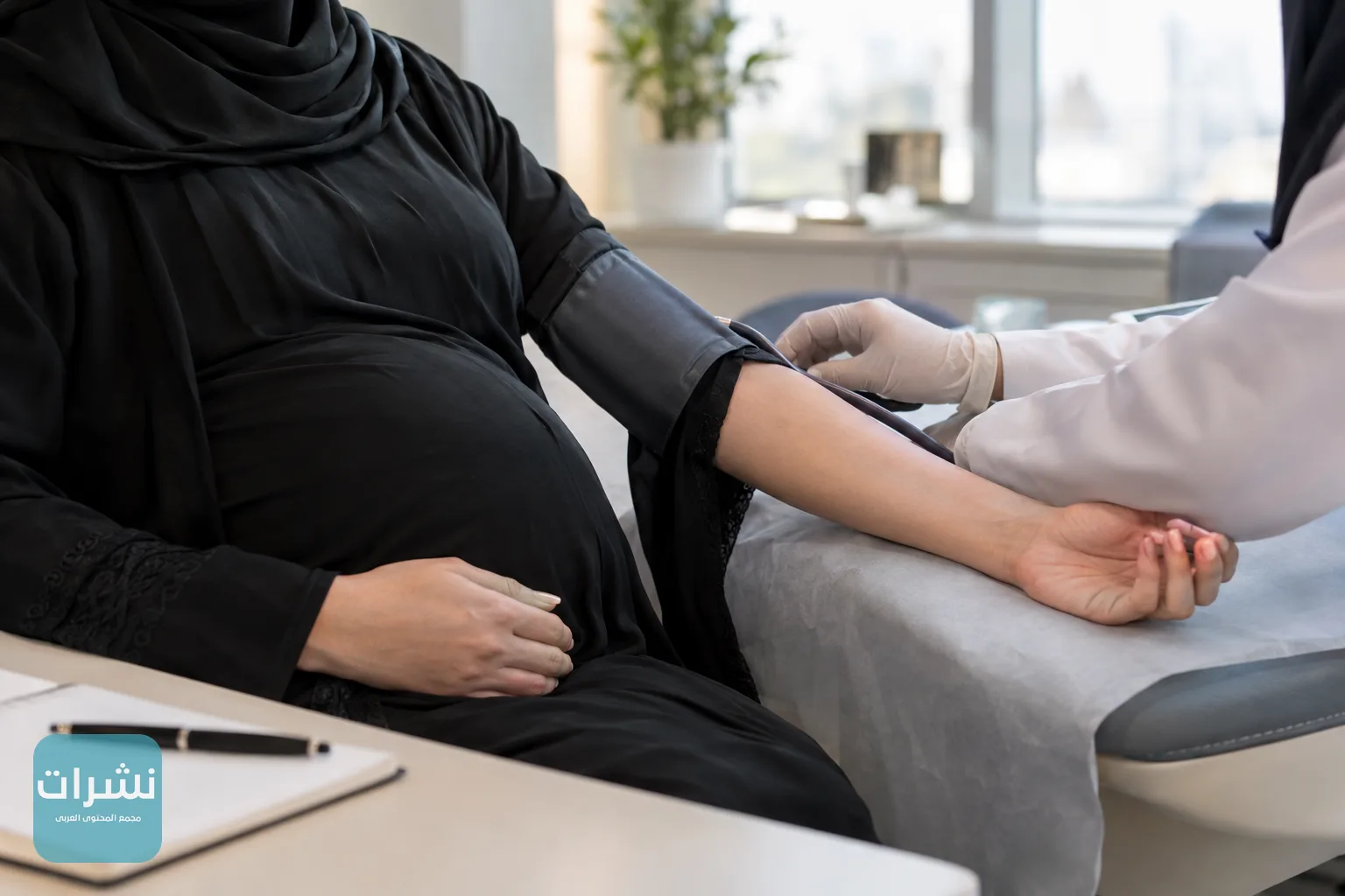 يد ممرضة تلف جهاز قياس الضغط حول ذراع حامل أثناء زيارة متابعة