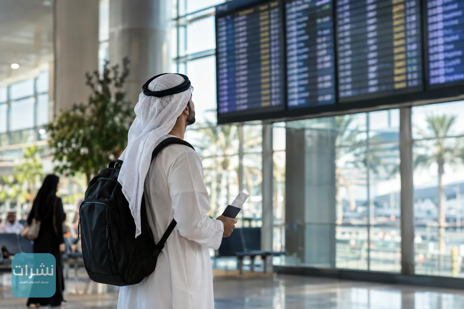 مسافر ينتظر أمام شاشة الرحلات في صالة مطار بالمملكة