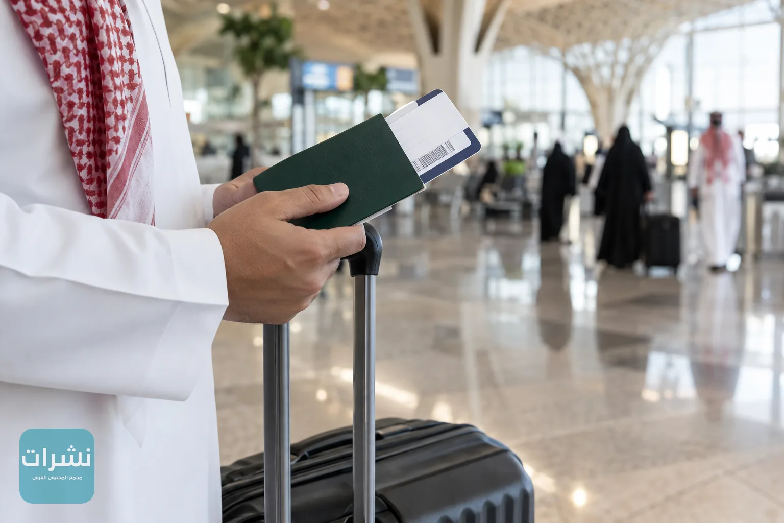 يد مسافر تحمل جواز سفر وبطاقة صعود بجانب حقيبة سفر في صالة مطار