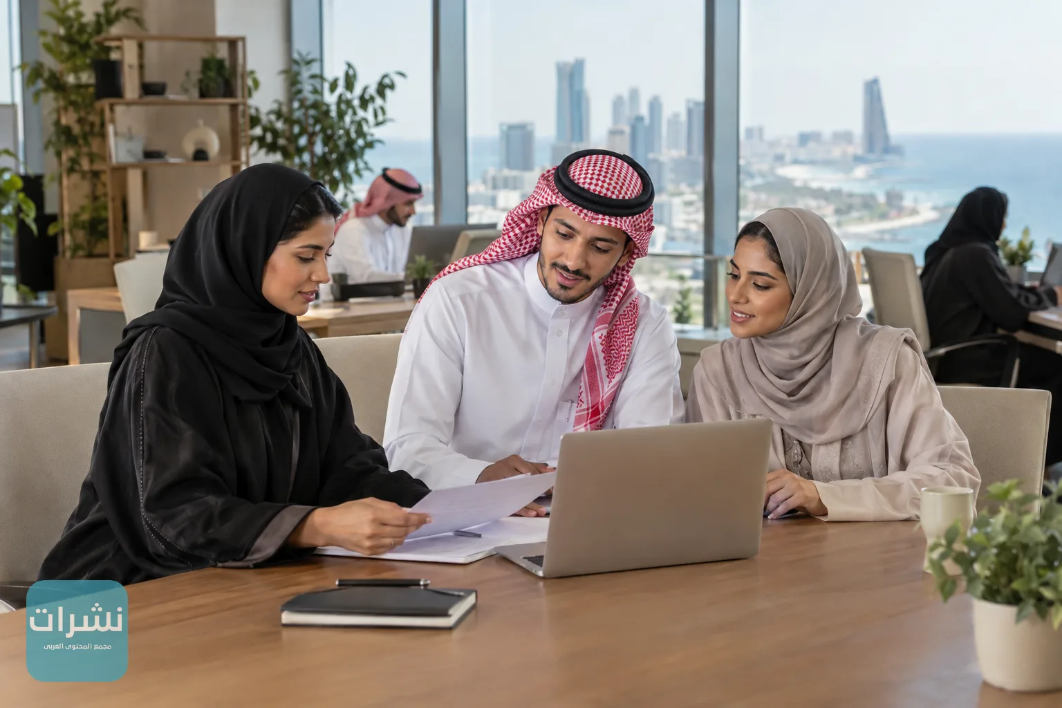 موظفون شباب يناقشون جدولًا للعمل في مكتب مفتوح بجدة